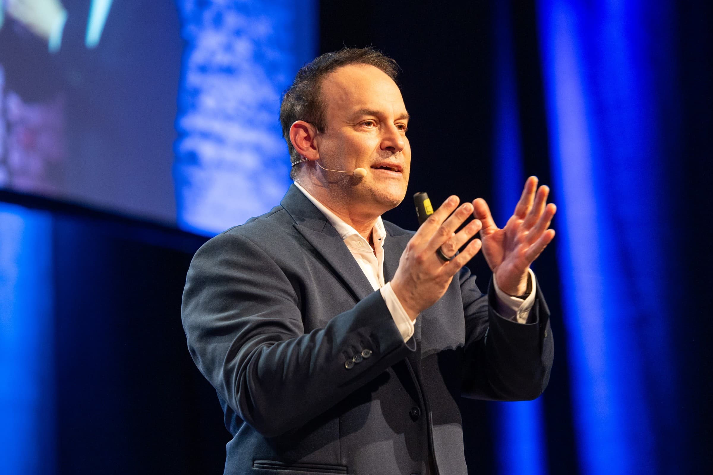 Michael Backes speaking at a lectern in front of a growth diagram